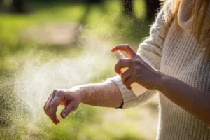 Insektsmedel Kvinnlig turist applicerar myggmedel på hand